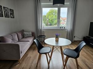a living room with a couch and a table and chairs at Apartamenty HARDOM in Opole