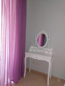 - une coiffeuse blanche avec un miroir et un rideau de douche rose dans l'établissement NOS LO MERECEMOS, à Puerto de Santiago
