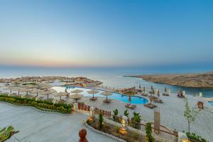 ハルガダにあるSiva Golden Bay Makadiのプールとパラソル付きのリゾートの景色を望めます。