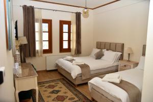 een slaapkamer met 2 bedden en een tafel bij NUCA GUESTHOUSE in Metsovo