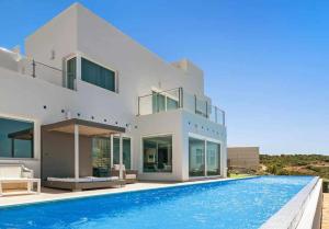duży biały dom z basenem w obiekcie LUJOSAVILLA PISCINA 25 METROS SUIT 60m2 SPA SAUNA w mieście Zahara de los Atunes
