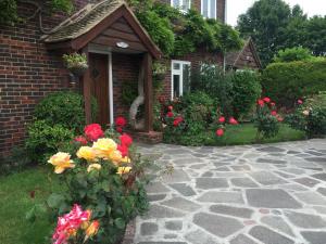 a brick house with flowers in the front yard at Clay Farm Guest House in Bromley