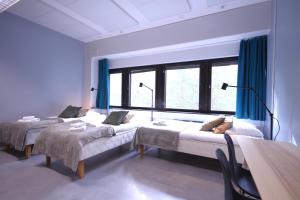a room with two beds and a large window at Forenom Hostel Espoo Kilo in Espoo