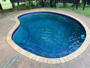 a small pool of blue water in a driveway at Private Villa with Private Pool - Kruger Park Lodge in Hazyview