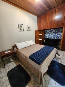 Un dormitorio con una cama, una mesa y una silla. en Pousada Pedacinho do Ceu suite Giulia 4, en Cunha