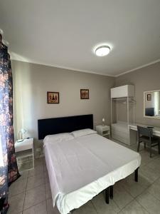 een slaapkamer met een groot wit bed en een tafel bij Hotel Le Rose in Tivoli Terme