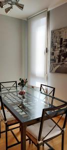 una mesa de cristal con dos sillas y un jarrón. en Apartamento 1 en Madrid