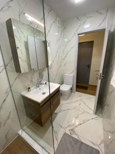 y baño con lavabo, espejo y aseo. en Tbilisi cozy appartment en Tiflis