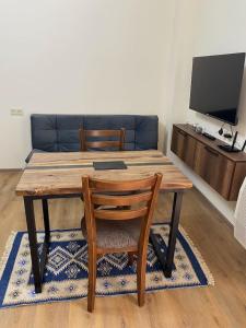 a wooden table and chairs in a living room with a couch at Tbilisi cozy appartment in Tbilisi City