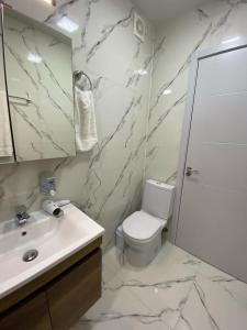 a white bathroom with a sink and a toilet at Tbilisi cozy appartment in Tbilisi City +24 photos