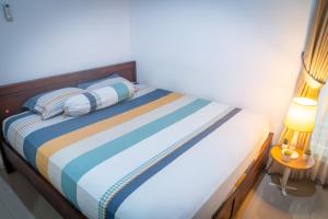 Schlafzimmer mit einem Bett mit blauen und gestreiften Kissen in der Unterkunft Cozy room only 20 minutes from the city center! in Ngaglik