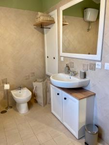 bagno con lavandino, servizi igienici e specchio di La Casa di Anna a Bagnoli