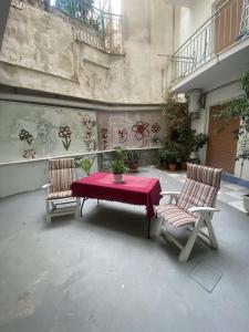 un patio con una mesa y 2 sillas con un paño rojo en Convenient Studio, en Atenas