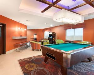 a billiard room with a pool table and a bar at MainStay Suites Hobbs in Hobbs