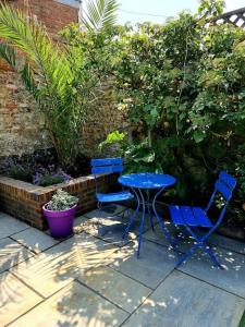 two blue chairs and a table in a garden at Central Location with Garden in Seaford