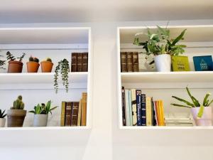 two white shelves with plants and books at Central Location with Garden in Seaford