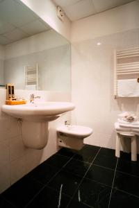 uma casa de banho com um lavatório e um WC em Essenza Hotel em Verrès