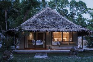a small hut with a thatched roof at Coral Eye Boutique Resort and Marine Outpost in Likupang