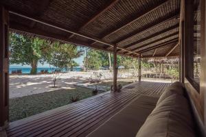- une vue sur la plage depuis la terrasse couverte d'une maison dans l'établissement Coral Eye Boutique Resort and Marine Outpost, à Likupang