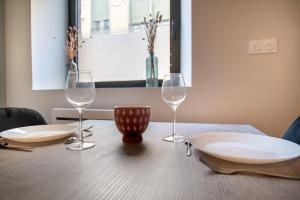 uma mesa de madeira com dois copos de vinho em studio banc léger cœur de ville em Limoges