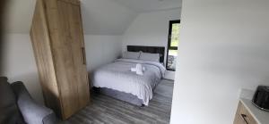 1 dormitorio con 1 cama y puerta de madera en The Rocks - Luxury Glamping Resort, en Newry