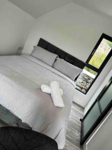 a bedroom with a bed with two white towels on it at The Rocks - Luxury Glamping Resort in Newry