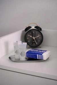 a clock sitting next to a toothbrush and a tube of toothpaste at Casa Silva Diamond in Pinhal Novo