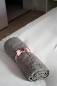 une chaussette grise avec une étrave rose sur un lit dans l'établissement Casa Silva Diamond, à Pinhal Novo