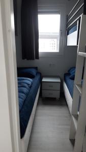 una piccola camera con due letti e una finestra di CS 34 - Vakantiepark Callassande a Callantsoog