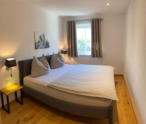 Schlafzimmer mit einem großen weißen Bett und einem Fenster in der Unterkunft Eggerbauer in Brixen im Thale
