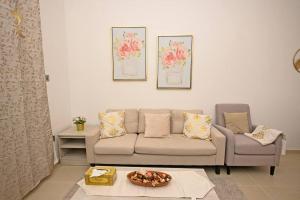 ein Wohnzimmer mit einem Sofa und einem Tisch in der Unterkunft Mangrove Bliss - Cozy 2BR Apartment in Abu Dhabi
