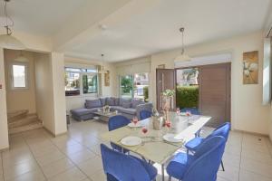 a dining room with a table and blue chairs at Delfini Villas in Protaras