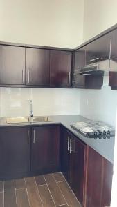 a kitchen with wooden cabinets and a counter top at Luxury Apartment near airport in Negombo
