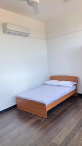 a bed in a room with a white wall at Luxury Apartment near airport in Negombo