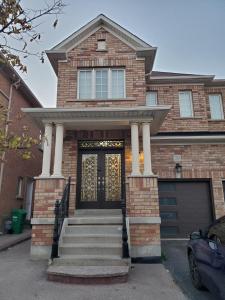 una casa de ladrillo con una puerta delantera con columnas en RAESABU GUEST HOUSE en Brampton