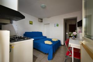 a small kitchen with a blue couch and a stove at Bivani a 100 m dal mare in Castellammare del Golfo