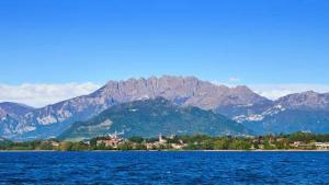 uma grande massa de água com montanhas ao fundo em IULI LAKE HOME Tra lago e montagna em Olginate