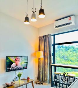 ein Wohnzimmer mit einem TV und einem Tisch in der Unterkunft Jesselton Quay by Adara Suites in Kota Kinabalu