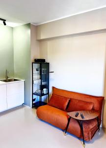 un sofá naranja en una habitación con mesa en Milan City Smart, en Cologno Monzese