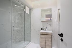 a white bathroom with a shower and a sink at Hestia - Romvis 9 in Athens