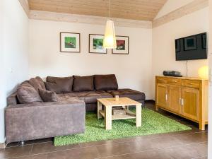 een woonkamer met een bank en een salontafel bij Ferienhaus Wiesengeflüster W3 - mit Fasssauna und Garten, 300 m zur Müritz in Röbel