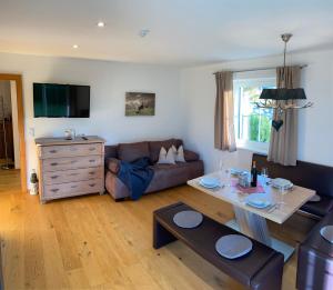 ein Wohnzimmer mit einem Sofa und einem Tisch in der Unterkunft Eggerbauer in Brixen im Thale