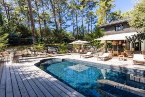 une arrière-cour avec une piscine et une maison dans l'établissement La Villa La Dune, à Lège-Cap-Ferret