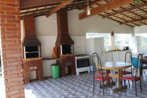 a kitchen with a table and chairs and a brick wall at Chalé Canto da Seriema in Joanópolis