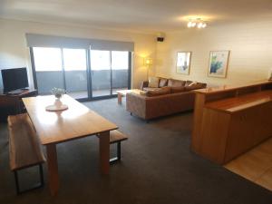 ein Wohnzimmer mit einem Sofa und einem Tisch in der Unterkunft Snow Ski Apartments 40 in Falls Creek