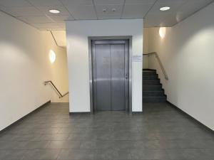 um corredor com uma porta e escadas num edifício em Hotel Efcannos Dornberg Carree em Vechelde