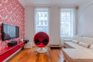倫敦的住宿－The "Red Room Apartment" - Fitzrovia - by Frankie Says，客厅配有电视前配有红色椅子