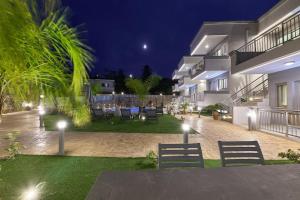 a courtyard of a house at night with lights at Comfy apartmt near beach with pool dining area in Stavromenos