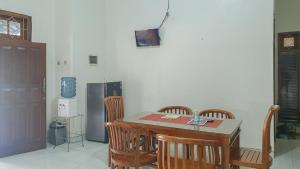 uma cozinha com uma mesa e cadeiras e um frigorífico em Villa Pakis Residence Banyuwangi em Banyuwangi