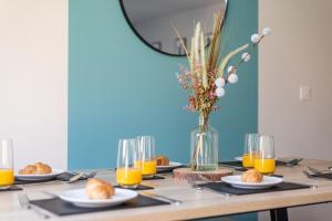 uma mesa com pratos de comida e um vaso de sumo de laranja em 3 Bedroom House Ashford, Kent - Free Parking - Free WiFi - Big Monthly Discounts - Sleeps 5 - Elite Stays UK em Ashford